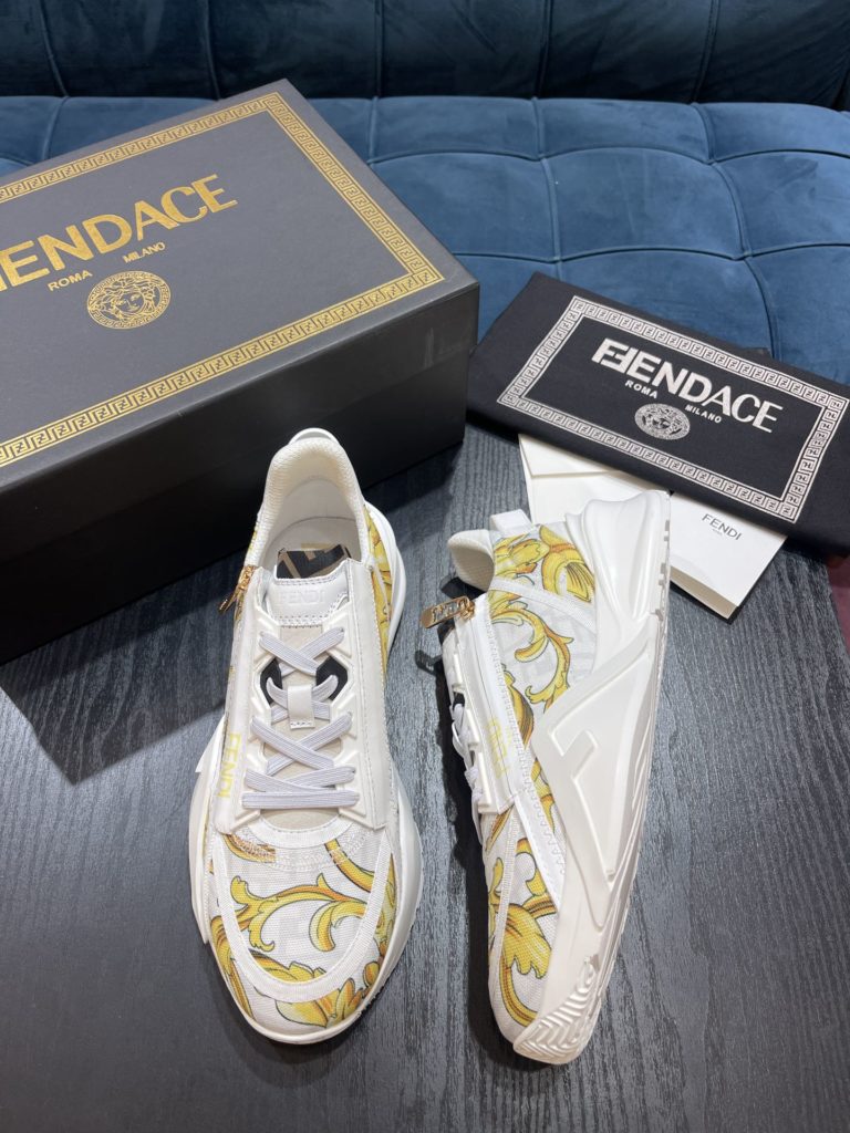 Versace by Fendi pedals sneakers with elastic laces and elastic inserts. The wavy sole is engraved with the word F. Embossed Fendi Flow on the heel. FF nylon with black and gold baroque scarf print. Lycra with FF pattern ® Tongue and Versace Medusa safety pin brooch shaped tab. Lightweight black rubber sole with diagonal F details. Made in Italy Size 39-44 (customized at 38.45)