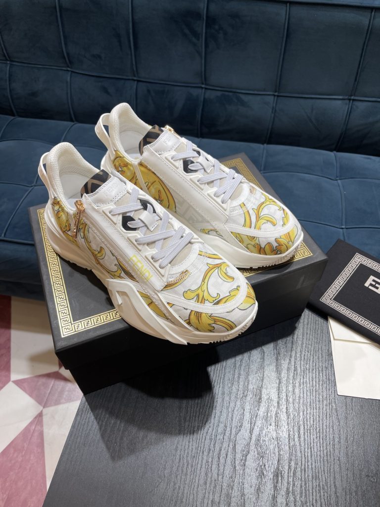 Versace by Fendi pedals sneakers with elastic laces and elastic inserts. The wavy sole is engraved with the word F. Embossed Fendi Flow on the heel. FF nylon with black and gold baroque scarf print. Lycra with FF pattern ® Tongue and Versace Medusa safety pin brooch shaped tab. Lightweight black rubber sole with diagonal F details. Made in Italy Size 39-44 (customized at 38.45)