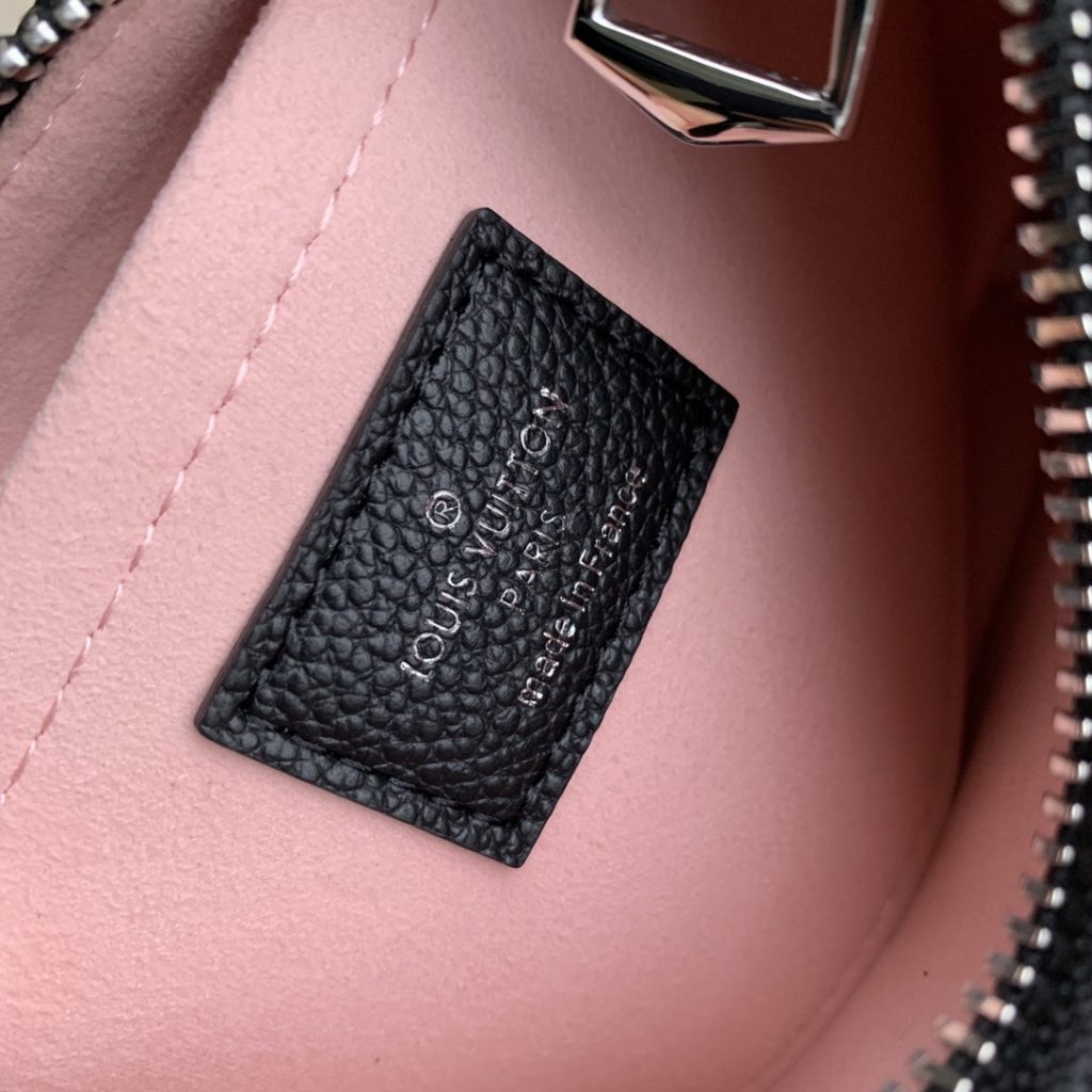 The M20998 Black Marellini handbag features Louis Vuitton's iconic Epi leather, incorporating the flexible elements of the Marelli handbag into a more compact configuration. The round zero wallet can be easily removed and fixed to the mirror of the bag body through a chain to rest in the front patch pocket. 19.0 x 13.5 x 6.5 cm (L x H x W)