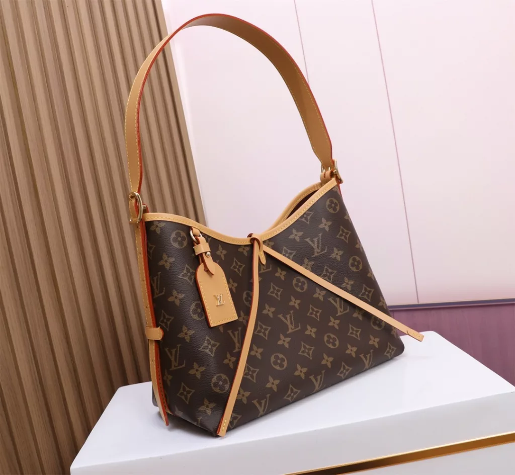 The M46203 CarryAll small bag features Monogram canvas and leather trim. The ample configuration features a neat lining, while the large inner bag adds functional elements. The Monogram canvas zipper clutch bag is secured with a leather strap. Dimensions: 29.0 x 24.0 x 12.0 cm
