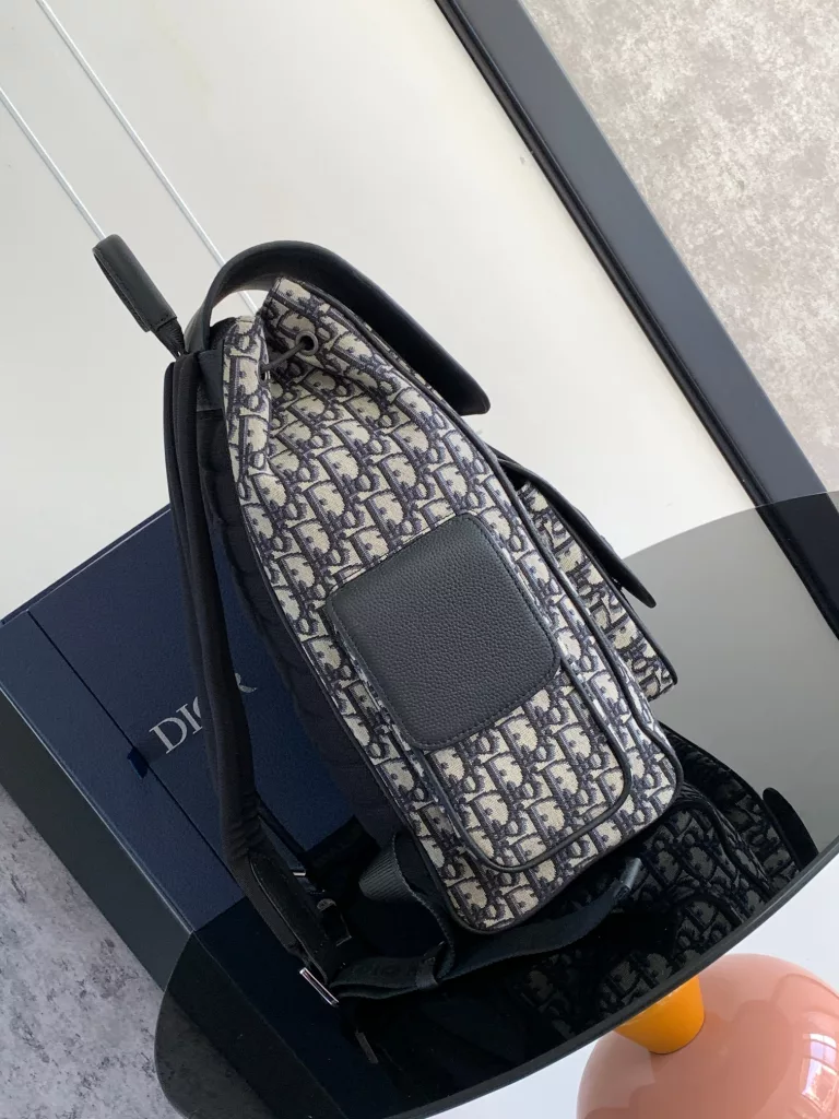 The Saddle backpack features a stylish, original design that highlights the saddle style. Crafted in beige and black Oblique printed jacquard fabric, decorated with black grain ox-leather details, the front is decorated with the 