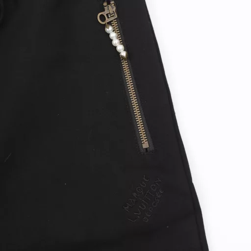Louis Vuitton Pearl Drop SweatpantsTechnical Cotton Pearl Embellished SweatpantsThese stylish sweatpants from the Spring/Summer 2024 runway show are embellished with sophisticated details for a casual and sophisticated look. Made from midnight blue percale technical cotton, they feature side pockets with pearl-detailed zipper pulls and can be worn with a pearl-embellished hoodie.