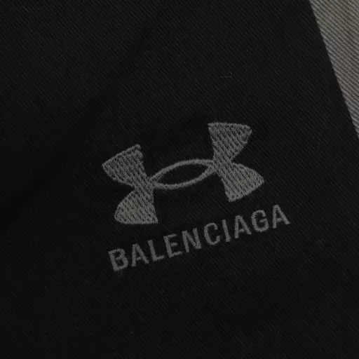 Balenciaga BLCG x Under Armour co-branded embroidered side stitching trousersCustomized luxurious velvet silk ultra-soft fabric, full of texture, comfortable and close to the skin, imported machine embroidery technology, high precision, smooth and delicate lines, two-color interlaced sequence stitching technology, first through infrared equal position cutting bed, and then through fine sewing and splicing, the splicing is natural, flat and tidy, forming a two-color interlaced visual effect, soft light ancient rhyme washing technology, through specific chemical and logistics treatment, the surface of the fabric presents a soft luster, and the slight wrinkles reflect a sense of old material, loose version