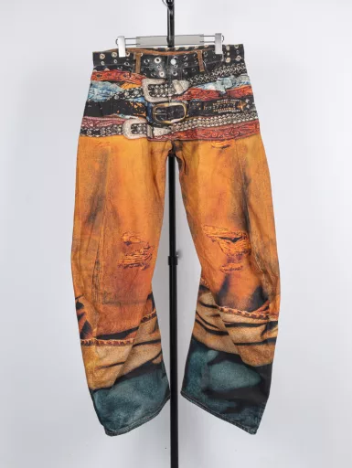 Denim trousers with multiple belt patternsThe woven canvas textured cotton fabric is thicker and stiffer than the previous chain print pants fabric. It looks more three-dimensional with the 2006 scimitar pants shape, and the coloring effect is also very good. Let's talk about the printing part. 3D printing cold transfer technology, after the plate is received, it is sent to scan and make files as soon as possible. A pair of pants must be divided into several areas for separate printing. In addition to the scimitar pattern, the pants must be spread out and flattened. After comparing with the original, adjustments are made slowly, including color, shape and other details. In particular, the waistband binding is really debugged several times to achieve the unique realistic visual effect of the bulk goods. The assembly of the garment also needs to be aligned and spliced. The scimitar pattern adds a lot of difficulty to the alignment. Each one hides many processes. After that, it is washed once to make it soft and ensure the three-dimensional effect. A full set of accessories is customized