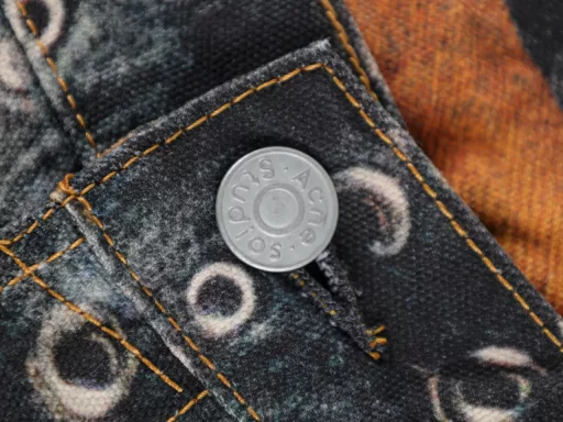 Denim trousers with multiple belt patternsThe woven canvas textured cotton fabric is thicker and stiffer than the previous chain print pants fabric. It looks more three-dimensional with the 2006 scimitar pants shape, and the coloring effect is also very good. Let's talk about the printing part. 3D printing cold transfer technology, after the plate is received, it is sent to scan and make files as soon as possible. A pair of pants must be divided into several areas for separate printing. In addition to the scimitar pattern, the pants must be spread out and flattened. After comparing with the original, adjustments are made slowly, including color, shape and other details. In particular, the waistband binding is really debugged several times to achieve the unique realistic visual effect of the bulk goods. The assembly of the garment also needs to be aligned and spliced. The scimitar pattern adds a lot of difficulty to the alignment. Each one hides many processes. After that, it is washed once to make it soft and ensure the three-dimensional effect. A full set of accessories is customized