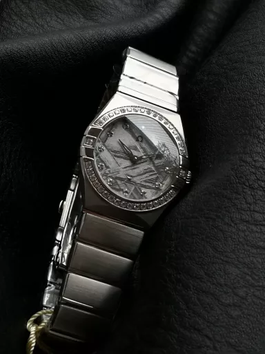 AS Omega fifth generation Constellation series 28mm Swiss quartz watch.The whole watch has been finely polished. The fit between the case and the claws, the Roman scale on the bezel and the restoration of the observatory on the bottom cover are comparable to the original.The dial uses mother-of-pearl material and unique etching technology to create the dial texture pattern, and the new Taiwan stone holder makes the lettering more delicate.The chamfers on both sides of the case and bracelet are hand-polished and polished by watchmakers to make the watch more refined! The style is gentle and moving, and the workmanship is exquisite. The most beautiful constellation, the first choice for ladies!
