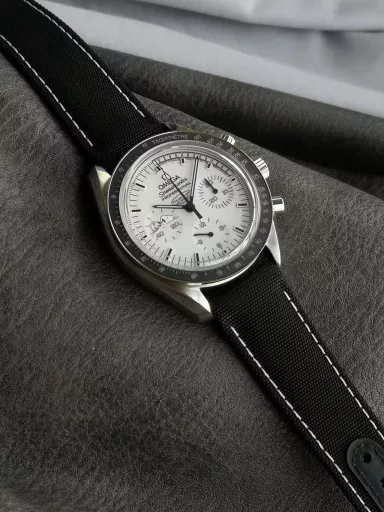 OM Exploration Magazine: Omega Speedmaster 311.32.42.30.04.003 watch (Snoopy Limited Edition), stainless steel case with black nylon leather strap, black lacquered hands, covered with Super-LumiNova luminous coating, equipped with manual mechanical chronograph movement, 42 mm.