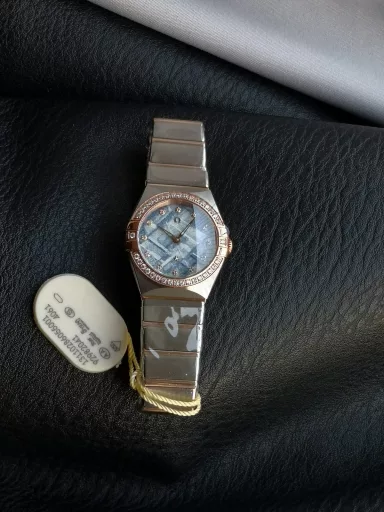AS Omega fifth generation Constellation series 28mm Swiss quartz watch.The whole watch has been finely polished. The fit between the case and the claws, the Roman scale on the bezel and the restoration of the observatory on the bottom cover are comparable to the original.The dial uses mother-of-pearl material and unique etching technology to create the dial texture pattern, and the new Taiwan stone holder makes the lettering more delicate.The chamfers on both sides of the case and bracelet are hand-polished and polished by watchmakers to make the watch more refined! The style is gentle and moving, and the workmanship is exquisite. The most beautiful constellation, the first choice for ladies!