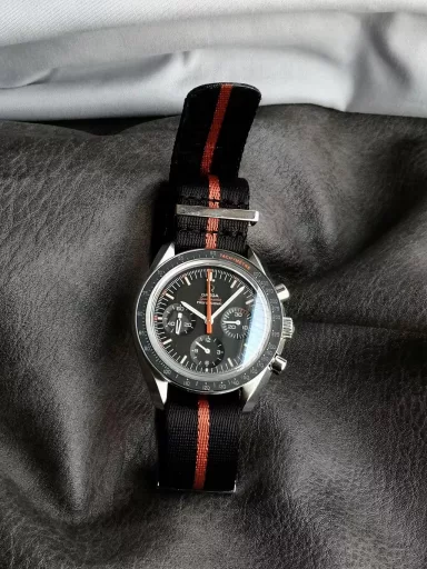 OM recommends: Omega Speedmaster 311.12.42.30.01.001 watch, stainless steel case, black anodized aluminum dial with orange elements, including the origin on the minute circle, the first 3 minutes of the small dial at 3 o'clock, and the famous 