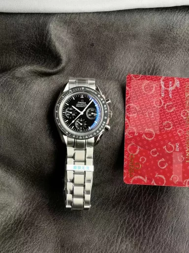 OM Exploration Magazine: Omega Speedmaster 311.32.42.30.04.003 watch (Snoopy Limited Edition), stainless steel case with black nylon leather strap, black lacquered hands, covered with Super-LumiNova luminous coating, equipped with manual mechanical chronograph movement, 42 mm.