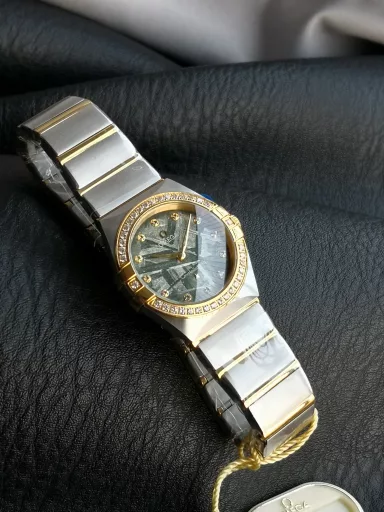 AS Omega fifth generation Constellation series 28mm Swiss quartz watch.The whole watch has been finely polished. The fit between the case and the claws, the Roman scale on the bezel and the restoration of the observatory on the bottom cover are comparable to the original.The dial uses mother-of-pearl material and unique etching technology to create the dial texture pattern, and the new Taiwan stone holder makes the lettering more delicate.The chamfers on both sides of the case and bracelet are hand-polished and polished by watchmakers to make the watch more refined! The style is gentle and moving, and the workmanship is exquisite. The most beautiful constellation, the first choice for ladies!