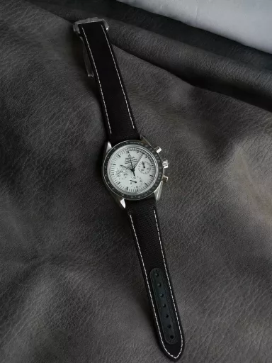OM Exploration Magazine: Omega Speedmaster 311.32.42.30.04.003 watch (Snoopy Limited Edition), stainless steel case with black nylon leather strap, black lacquered hands, covered with Super-LumiNova luminous coating, equipped with manual mechanical chronograph movement, 42 mm.