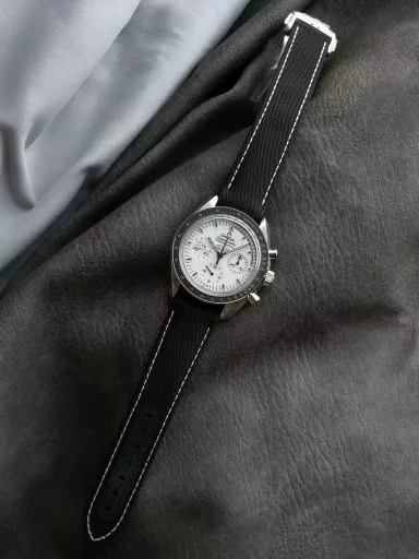 OM Exploration Magazine: Omega Speedmaster 311.32.42.30.04.003 watch (Snoopy Limited Edition), stainless steel case with black nylon leather strap, black lacquered hands, covered with Super-LumiNova luminous coating, equipped with manual mechanical chronograph movement, 42 mm.