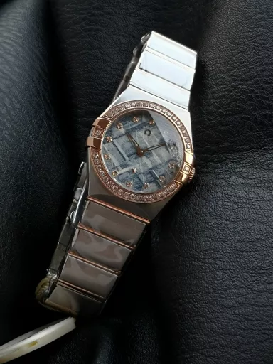 AS Omega fifth generation Constellation series 28mm Swiss quartz watch.The whole watch has been finely polished. The fit between the case and the claws, the Roman scale on the bezel and the restoration of the observatory on the bottom cover are comparable to the original.The dial uses mother-of-pearl material and unique etching technology to create the dial texture pattern, and the new Taiwan stone holder makes the lettering more delicate.The chamfers on both sides of the case and bracelet are hand-polished and polished by watchmakers to make the watch more refined! The style is gentle and moving, and the workmanship is exquisite. The most beautiful constellation, the first choice for ladies!