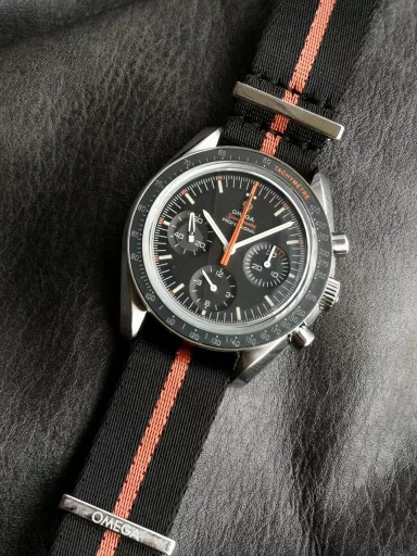 OM recommends: Omega Speedmaster 311.12.42.30.01.001 watch, stainless steel case, black anodized aluminum dial with orange elements, including the origin on the minute circle, the first 3 minutes of the small dial at 3 o'clock, and the famous 