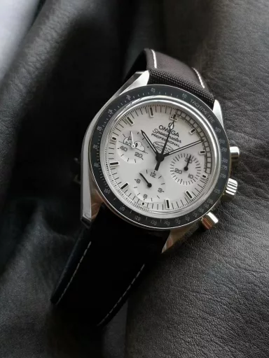OM Exploration Magazine: Omega Speedmaster 311.32.42.30.04.003 watch (Snoopy Limited Edition), stainless steel case with black nylon leather strap, black lacquered hands, covered with Super-LumiNova luminous coating, equipped with manual mechanical chronograph movement, 42 mm.