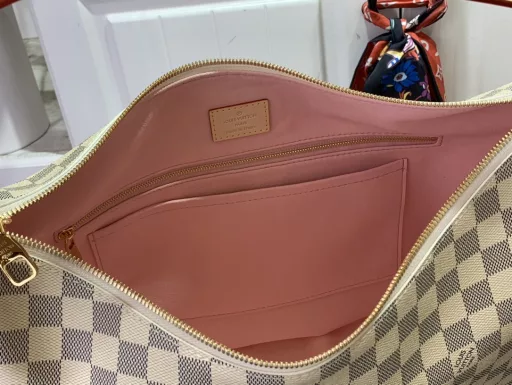This upgraded version of Slouchy MM shows the Damier Azur pattern of the house as a graphic signature. Fully functional and delicate, it is made of coated canvas with a unique pattern created using gravity printing. It has an iconic padlock nameplate and there's plenty of room inside for the essentials that work into the weekend.