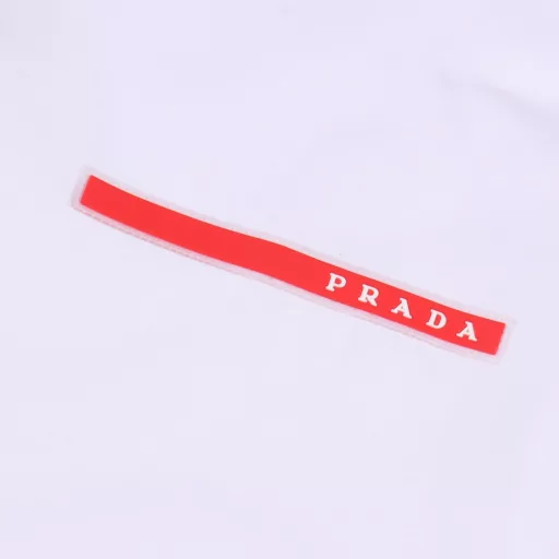 Prada 25SS Basic Red Silicone Short Sleeve T-shirtLight luxury, a must-have item for men and women's daily commuting wear, correct version, free comparisonDetailed features· 260g 100% cotton double yarn jersey fabric· Dust-free singeing process on the face, hair absorption on the bottom, environmentally friendly active dyeing· Special thickened 32 double strands 1×1 ribbing dyed in the same vat· Customized silicone small label with mold opening· Double needle sewing cross-seam process· Original main label washing tag packaging