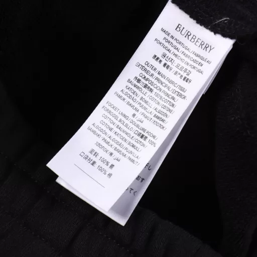 Burberry BBR Checked Cotton Back Pocket Applique ShortsThe lightweight cotton fabric is made of cotton fiber as the main raw material. The front is a smooth cotton surface, and the other side is raised to form a fine fluffy surface, which is breathable, moisture-absorbent and soft. The waist is designed with an elastic band, with drawstring adjustment. The elastic waist band is sewn with elastic bands, and the line spacing is tight, making it more firm, flat and beautiful while taking into account good elasticity. There are pockets on both sides, and the bag opening is reinforced by the tacking process. The edge of the back patch pocket is sewn on the hip position using the three-needle four-thread inlay process to enhance the visual beauty and durability. The bag body is decorated with the brand's classic checkered warhorse logo applique, and customized accessories