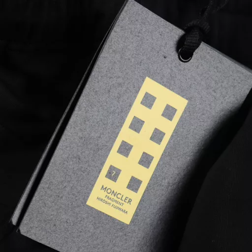MC MOCLER X Hiroshi Fujiwara Joint Badge ShortsMade of 100% pure cotton, the surface is treated with fleece to form a cotton fleece fabric, which has a soft and delicate touch and evenly distributed fluff. The natural structure of cotton fiber provides good moisture absorption and perspiration ability, is skin-friendly and non-irritating, and is also lightweight, making it burden-free to wear. The MOCLER&FRGMT embroidery process is used on the back pocket. The double-thread winding structure makes the embroidery surface thick and not easy to wear. The stitches are hidden on the back of the fabric, without messy threads, which improves durability and aesthetics. The letters starting with G27507 are decorated under the side pocket using the glue printing process, which has a three-dimensional visual effect and a bumpy and soft texture. It is not easy to fall off through high-temperature foaming. Customized accessories