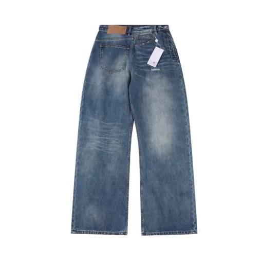 Margiela MM6 patch distressed denim trousersCustomized denim rough twill cotton satin, combined with rubbing and pressing cat whisker technology and gun painting cat whisker technology, manual rubbing is preferred in specific areas to achieve natural wrinkle effects, and then specific tools are used to draw cat whisker-shaped textures to maximize visual effects, the holes are made with rotten edge hanging rotten technology, and the natural rotten edge effect is achieved by rubbing the edges through physical wear, and the fiber hairiness and color difference are removed through the combination of high-temperature steam and sandpaper, so that the jeans present unique holes and wear effects, heavy washing and spraying dirty process, through physical and chemical means, use a spray gun to evenly spray water-soluble dyes on the denim fabric, the dye will form natural spots and stains on the surface of the fabric, simulating the wear marks after long-term wear, customized accessories, loose version