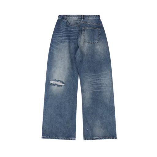 Margiela MM6 patch distressed denim trousersCustomized denim rough twill cotton satin, combined with rubbing and pressing cat whisker technology and gun painting cat whisker technology, manual rubbing is preferred in specific areas to achieve natural wrinkle effects, and then specific tools are used to draw cat whisker-shaped textures to maximize visual effects, the holes are made with rotten edge hanging rotten technology, and the natural rotten edge effect is achieved by rubbing the edges through physical wear, and the fiber hairiness and color difference are removed through the combination of high-temperature steam and sandpaper, so that the jeans present unique holes and wear effects, heavy washing and spraying dirty process, through physical and chemical means, use a spray gun to evenly spray water-soluble dyes on the denim fabric, the dye will form natural spots and stains on the surface of the fabric, simulating the wear marks after long-term wear, customized accessories, loose version