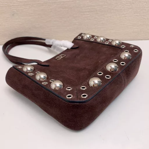 Small GARAVANI NELLCÔTE calfskin bag with ball studs and circular cutouts.
