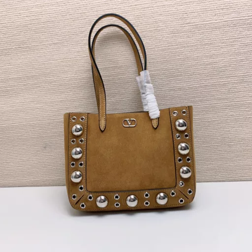 Small GARAVANI NELLCÔTE calfskin bag with ball studs and circular cutouts.