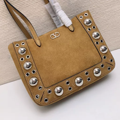 Small GARAVANI NELLCÔTE calfskin bag with ball studs and circular cutouts.