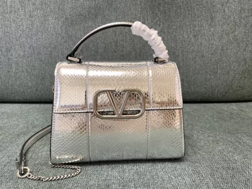 Valentino Garavani VSLING | Valentino | Golden Snake Professional Briefcase 💼With an extendable color-blocked shoulder strap and handle, it can be easily carried on the shoulder, crossbody or by hand. Retro-styled brass metal accessories with magnetic buckle closure, with adjustable chain leather shoulder strap with iconic logo, foot guard at the bottom of the bag, and nappa leather lining. Interior: 2 compartments, 1 zipper pocket and 1 flat open pocket