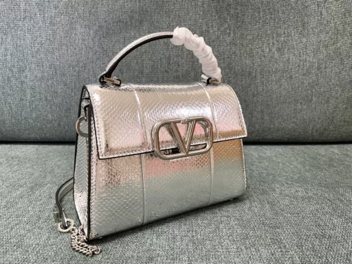 Valentino Garavani VSLING | Valentino | Golden Snake Professional Briefcase 💼With an extendable color-blocked shoulder strap and handle, it can be easily carried on the shoulder, crossbody or by hand. Retro-styled brass metal accessories with magnetic buckle closure, with adjustable chain leather shoulder strap with iconic logo, foot guard at the bottom of the bag, and nappa leather lining. Interior: 2 compartments, 1 zipper pocket and 1 flat open pocket