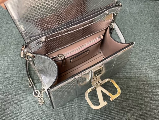 Valentino Garavani VSLING | Valentino | Golden Snake Professional Briefcase 💼With an extendable color-blocked shoulder strap and handle, it can be easily carried on the shoulder, crossbody or by hand. Retro-styled brass metal accessories with magnetic buckle closure, with adjustable chain leather shoulder strap with iconic logo, foot guard at the bottom of the bag, and nappa leather lining. Interior: 2 compartments, 1 zipper pocket and 1 flat open pocket