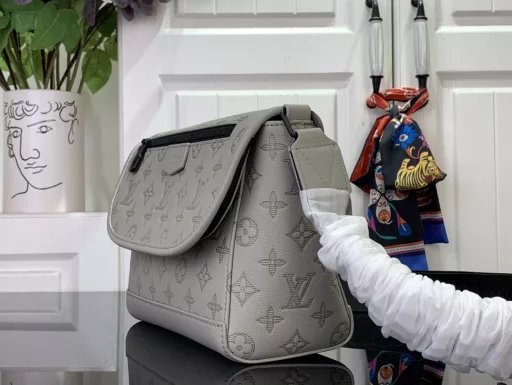The sporty silhouette is enhanced with Monogram Shadow embossed leather and sophisticated hardware, and the flap is decorated with zipper pockets above and below. The adjustable fabric shoulder strap allows for shoulder or crossbody carry.
