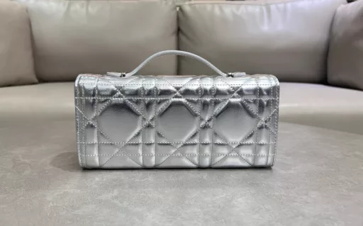New to the Cruise 2025 collection, the Miss Caro Top Handle Clutch is an everyday piece that exudes sophistication. Crafted from lambskin leather with oversized cannage stitching, the flap features a vintage gold-finish metal knob-style CD buckle, inspired by the closure of a Christian Dior perfume bottle, and a compartment for storing daily essentials. It can be carried by hand with a foldable top handle for a refined look.