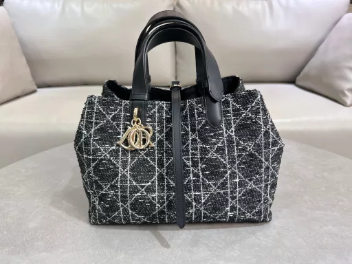 The Dior Toujours bag is casual and practical, with a twist. Crafted from calfskin leather with oversized cannage stitching and black calfskin details, it features a spacious interior with matching pouches to neatly organize your daily essentials. It has a slim leather tie closure to keep everything secure, and a CD Lock D knob clasp that adjusts the sides for added style. Medium size with leather top handle with adjustable details for hand or shoulder carry