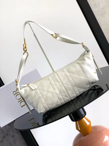 New this season, the D-Journey bag made its debut at the Dior Spring/Summer 2025 ready-to-wear show. It's soft and modern, with a modern take on the dumpling bag silhouette. Crafted from white crinkled calfskin leather, it's decorated with flat, oversized rattan stitching, a new take on Dior's classic motif. The main compartment features a zippered pocket for added refinement, and two decorative side pockets with large leather zipper pulls embellished with the Christian Dior Paris logo. The medium size, with an adjustable top leather handle and leather shoulder strap, can be carried by hand, on the shoulder or across the body, making it an ideal companion for everyday styling