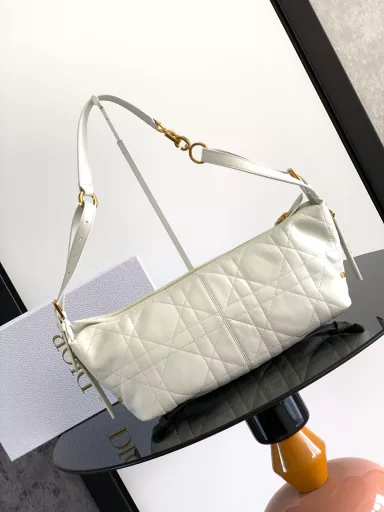 New this season, the D-Journey bag made its debut at the Dior Spring/Summer 2025 ready-to-wear show. It's soft and modern, with a modern take on the dumpling bag silhouette. Crafted from white crinkled calfskin leather, it's decorated with flat, oversized rattan stitching, a new take on Dior's classic motif. The main compartment features a zippered pocket for added refinement, and two decorative side pockets with large leather zipper pulls embellished with the Christian Dior Paris logo. The medium size, with an adjustable top leather handle and leather shoulder strap, can be carried by hand, on the shoulder or across the body, making it an ideal companion for everyday styling