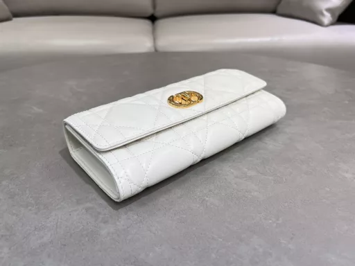 New to the Cruise 2025 collection, the Miss Caro Top Handle Clutch is an everyday piece that exudes sophistication. Crafted from burgundy lambskin leather with oversized cannage stitching, the flap features a vintage gold-finish metal knob-style CD buckle, inspired by the closure of a Christian Dior perfume bottle, and a compartment for storing a variety of daily necessities. With a foldable top handle, it can be carried by hand, enhancing the sophisticated look.