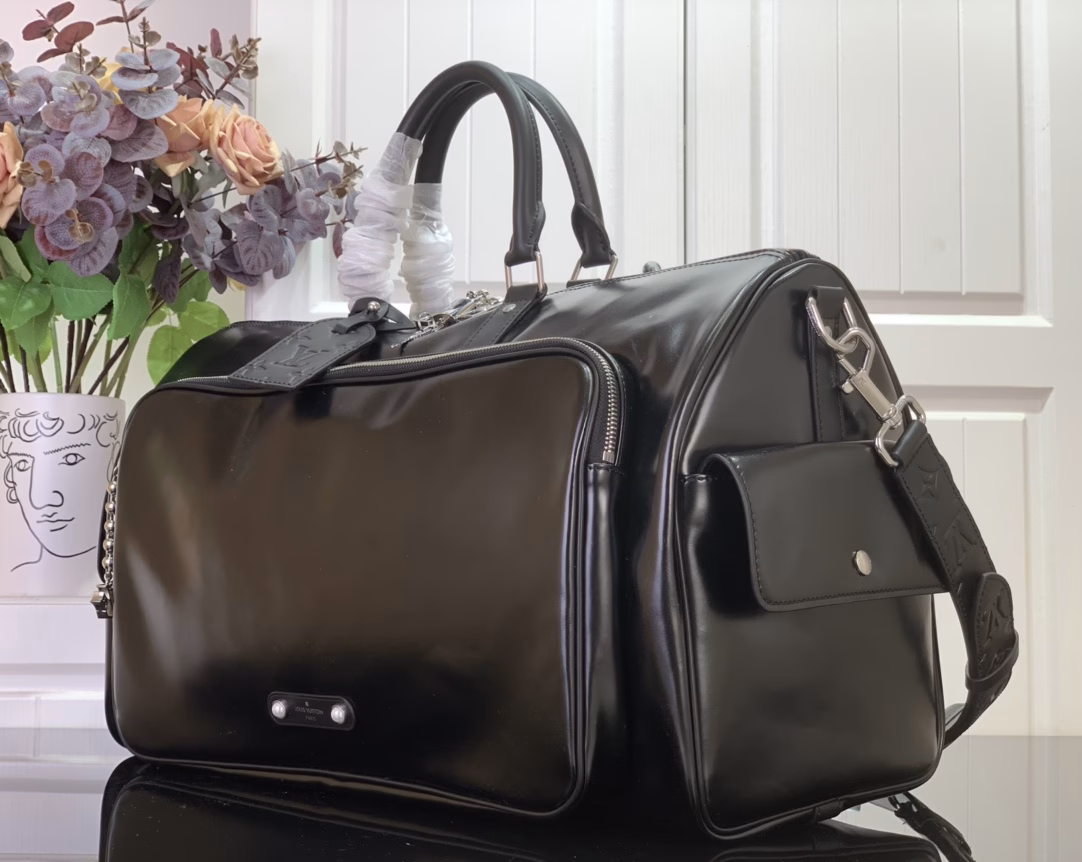 This Keepall Cargo Bandoulière 50 travel bag is made of shiny cowhide leather dyed in a deep color, allowing the classic design to capture the changes in light and shadow between movement and stillness, showing Pharrell Williams' inspiration for the hazy night. The LV monogram decoration and zipper pull on the zippered outer pocket add a metallic luster.