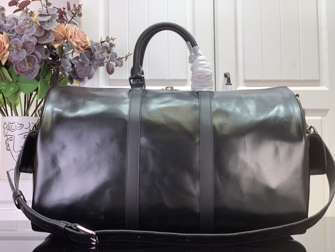 This Keepall Cargo Bandoulière 50 travel bag is made of shiny cowhide leather dyed in a deep color, allowing the classic design to capture the changes in light and shadow between movement and stillness, showing Pharrell Williams' inspiration for the hazy night. The LV monogram decoration and zipper pull on the zippered outer pocket add a metallic luster.