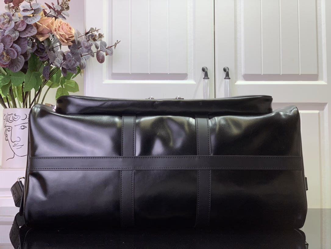This Keepall Cargo Bandoulière 50 travel bag is made of shiny cowhide leather dyed in a deep color, allowing the classic design to capture the changes in light and shadow between movement and stillness, showing Pharrell Williams' inspiration for the hazy night. The LV monogram decoration and zipper pull on the zippered outer pocket add a metallic luster.