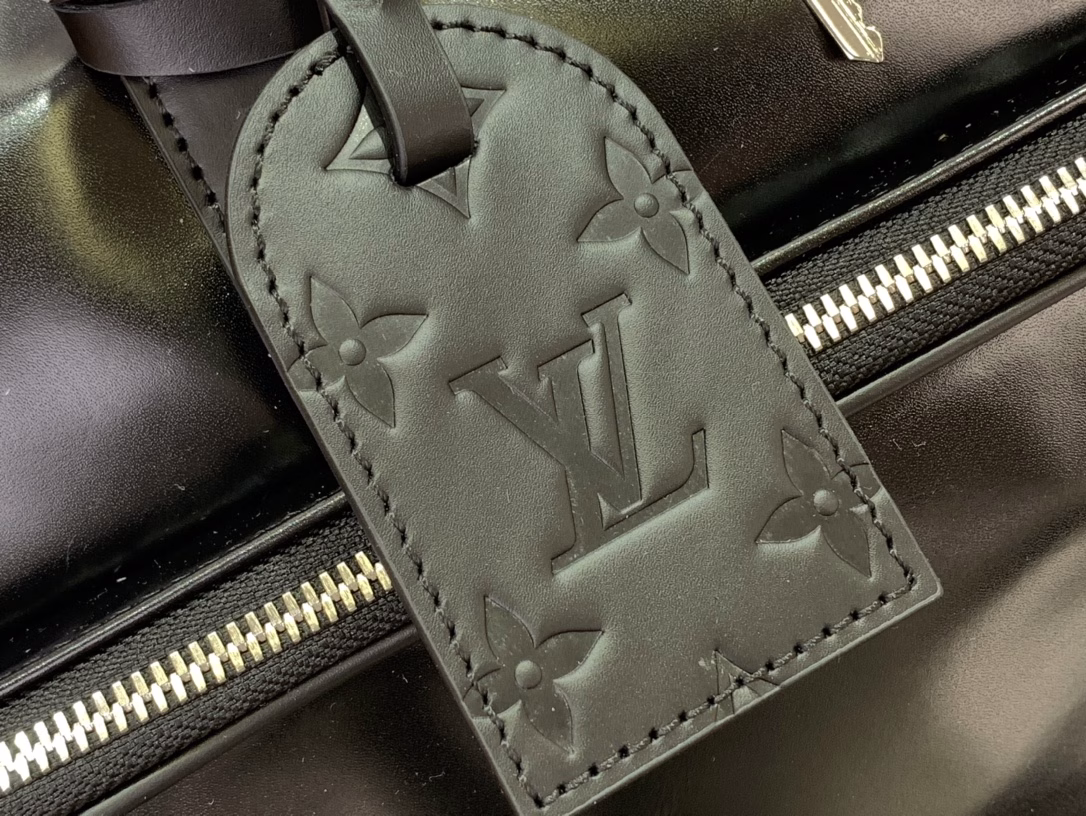 This Keepall Cargo Bandoulière 50 travel bag is made of shiny cowhide leather dyed in a deep color, allowing the classic design to capture the changes in light and shadow between movement and stillness, showing Pharrell Williams' inspiration for the hazy night. The LV monogram decoration and zipper pull on the zippered outer pocket add a metallic luster.