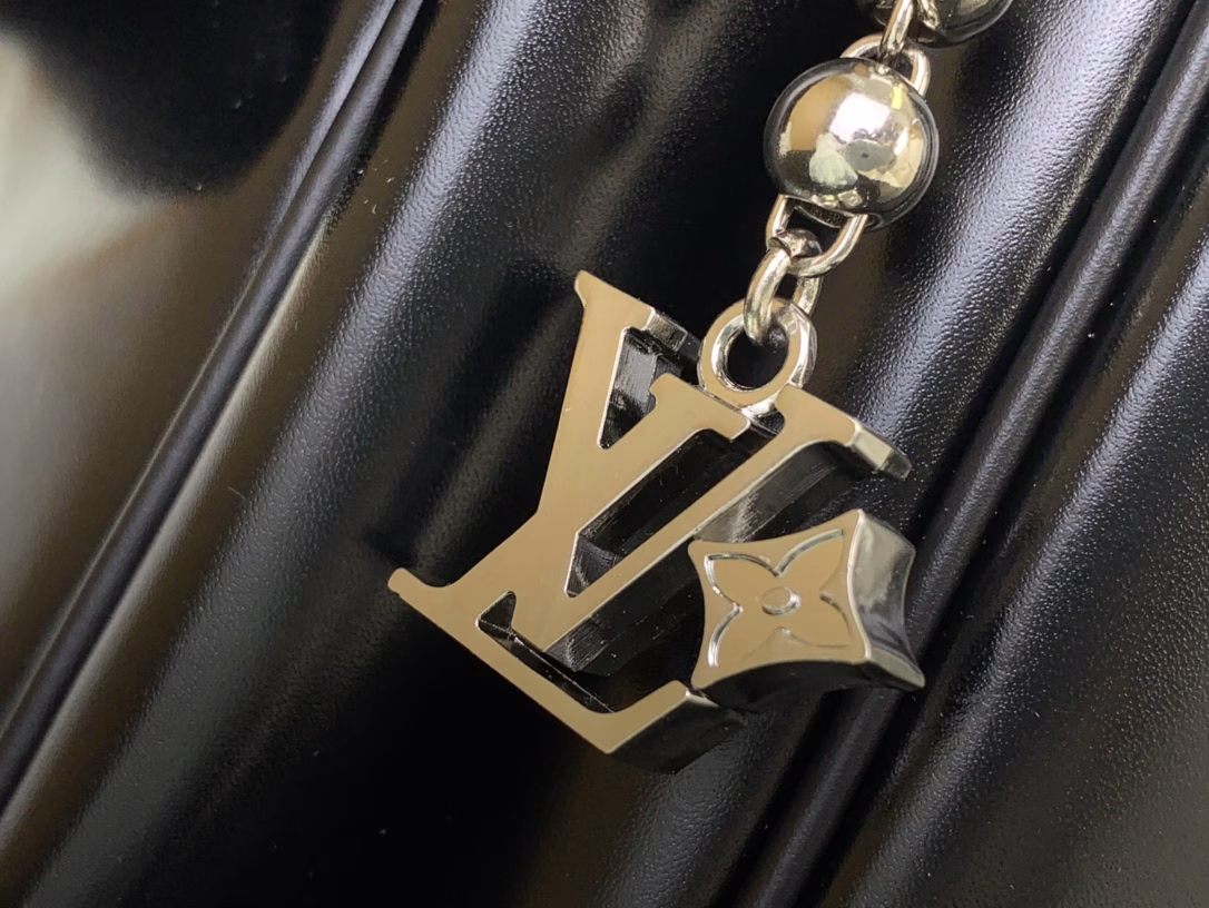 This Keepall Cargo Bandoulière 50 travel bag is made of shiny cowhide leather dyed in a deep color, allowing the classic design to capture the changes in light and shadow between movement and stillness, showing Pharrell Williams' inspiration for the hazy night. The LV monogram decoration and zipper pull on the zippered outer pocket add a metallic luster.