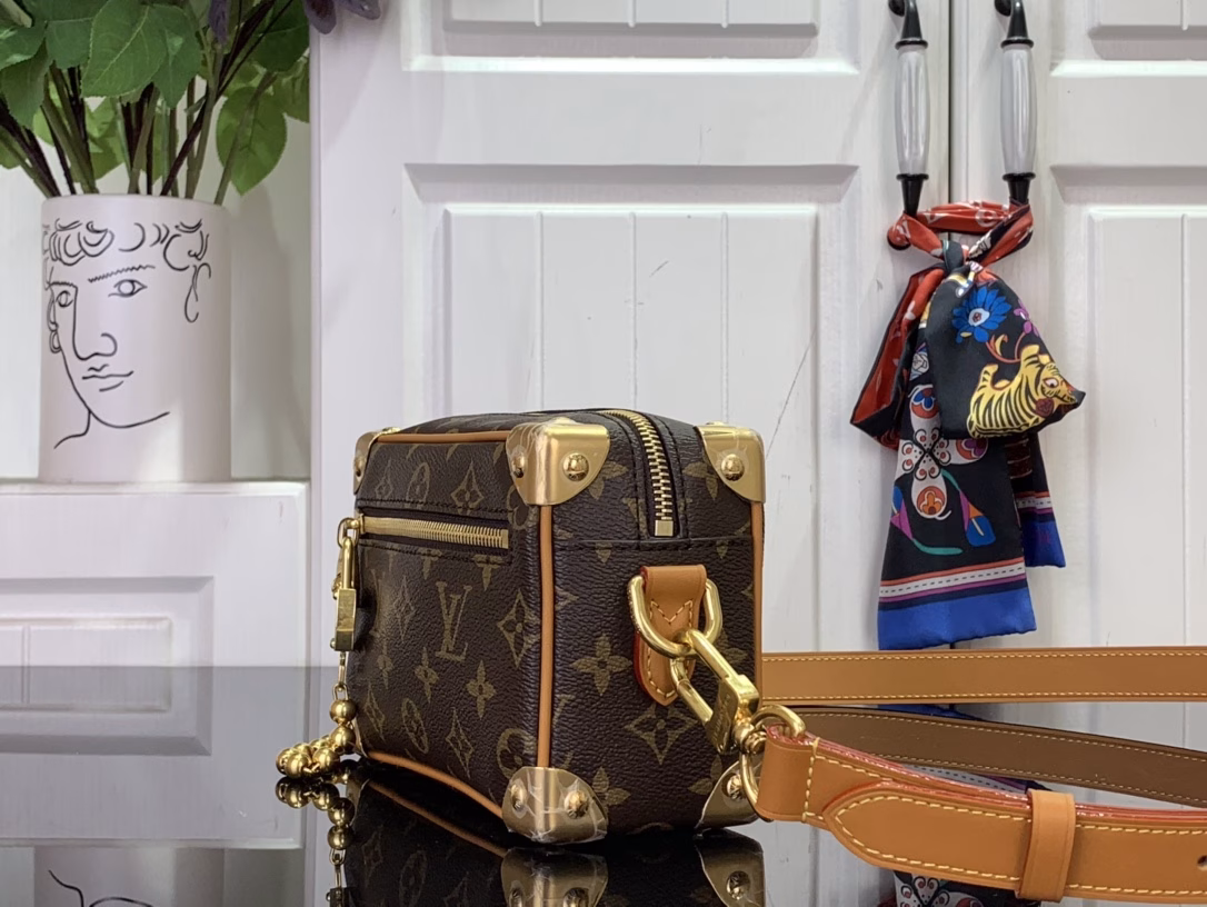 The mini soft luggage is made of Monogram coated canvas with natural cowhide leather trim. It features a gold ball chain and a new decorative padlock engraved with the 