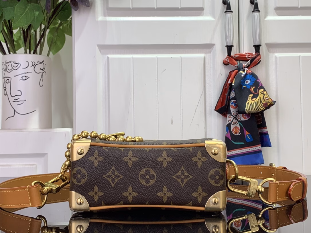 The mini soft luggage is made of Monogram coated canvas with natural cowhide leather trim. It features a gold ball chain and a new decorative padlock engraved with the 