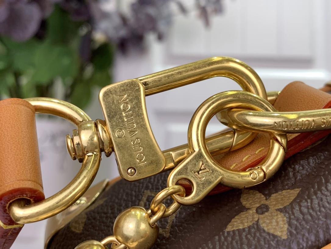 The mini soft luggage is made of Monogram coated canvas with natural cowhide leather trim. It features a gold ball chain and a new decorative padlock engraved with the 