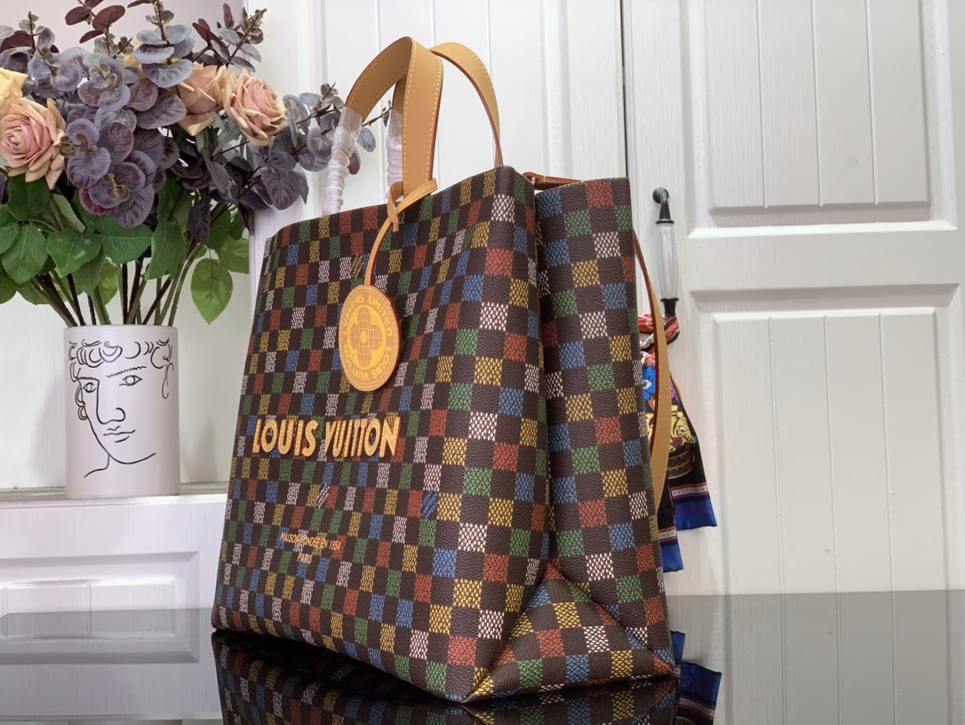 The Shopper Tote is inspired by the classic Louis Vuitton shopping bag, featuring the same clean lines and contrasting Louis Vuitton monogram. This bag is made of LVers Damier Ebene coated canvas with Pharrell Williams' colorful reinterpretation of the Damier pattern (inspired by the classic design created by Georges Vuitton in 1888). Two top handles and a removable shoulder strap provide flexible carrying options, combining practicality and unique charm.