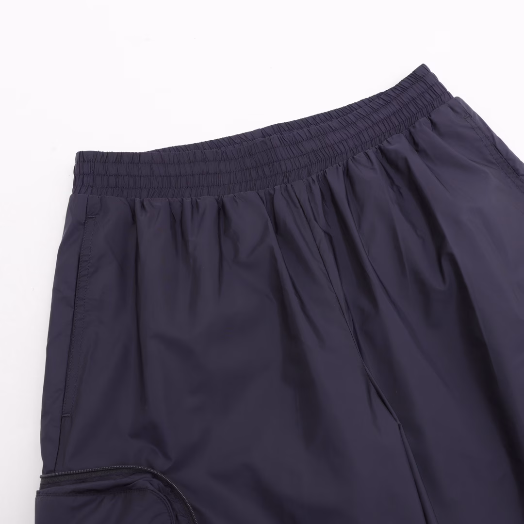 Moncco MC three-party joint storage nylon shortsMade of 100% customized nylon nylon fabric, the tear-resistant surface is created through high-density warp and weft weaving technology. The single-layer weight is precisely controlled at about 150g/㎡, making it light, easy to wear and smooth to the touch. Nylon itself has good elasticity and is not easy to wrinkle, maintaining long-term flatness. In daily life, it has a certain resistance to acids, alkalis, oils, etc., and is easy to clean and care for. The lining is also made of nylon, and a fine mesh design is adopted because good breathability is required. It is smooth and skin-friendly when worn close to the body, and it is not easy to pilling and breakage due to long-term friction, which prolongs the service life. The side work pocket of the emblem has a built-in seamless folding structure. When unfolded, it is a three-dimensional storage space. When folded, it is closed by a hidden zipper to form a compact storage bag. The main logo patch is molded with liquid silicone, with a thickness of 2.2mm. The edge simulates the chrome-plated effect of the car logo. The patch stitching is alternately woven with polyester thread, with 12 stitches per inch to ensure that it will not fall off after long-term washing. Customized Accessories