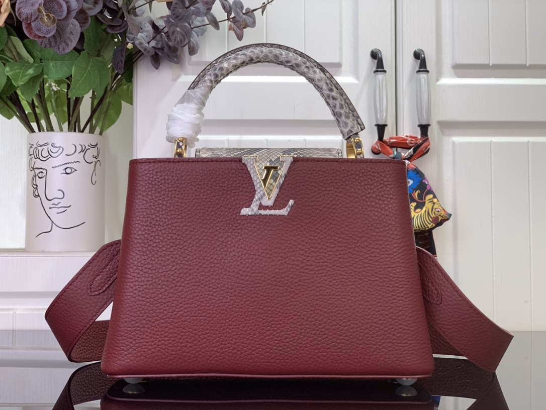 The Capucines bb bag features light blue Taurillon leather for a sophisticated feminine appeal, juxtaposed with precious Karung leather on the flap and top handle. Although soft to the touch, Karung leather is extremely durable, making it long-lasting. In addition to the iconic top handle, the Capucines also features a wide, removable shoulder strap.