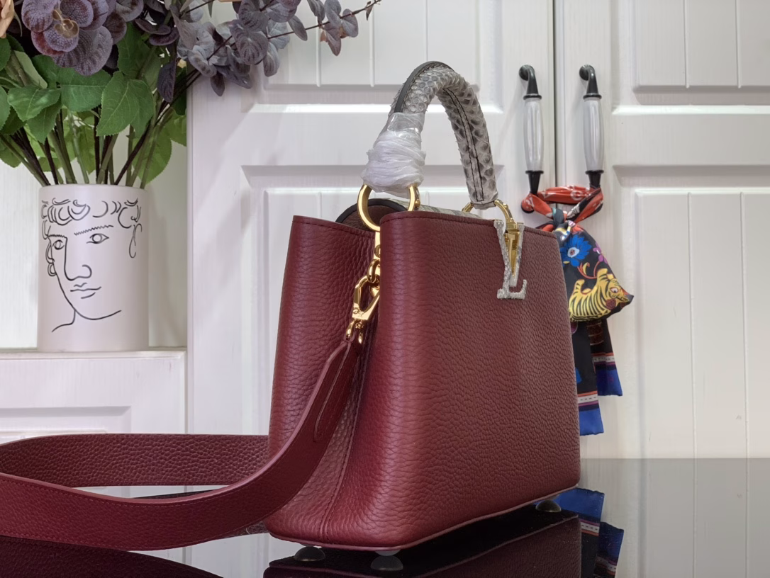 The Capucines bb bag features light blue Taurillon leather for a sophisticated feminine appeal, juxtaposed with precious Karung leather on the flap and top handle. Although soft to the touch, Karung leather is extremely durable, making it long-lasting. In addition to the iconic top handle, the Capucines also features a wide, removable shoulder strap.